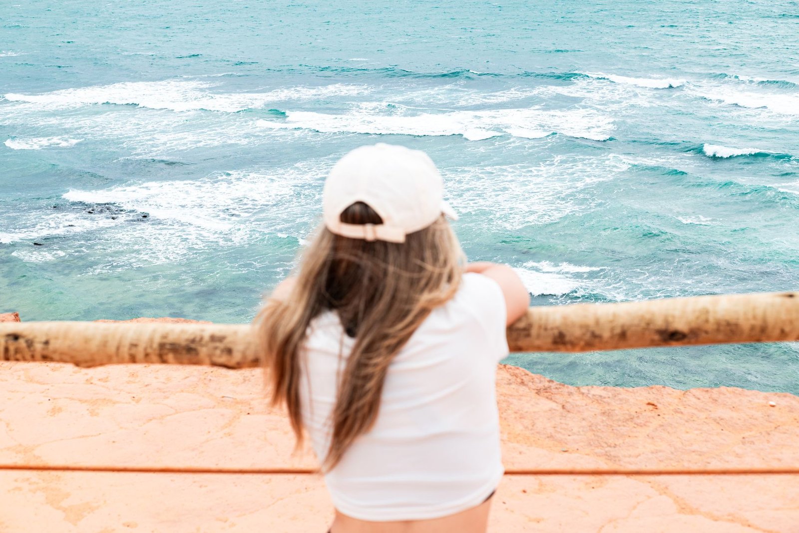 young woman enjoying ocean view from cliffs
